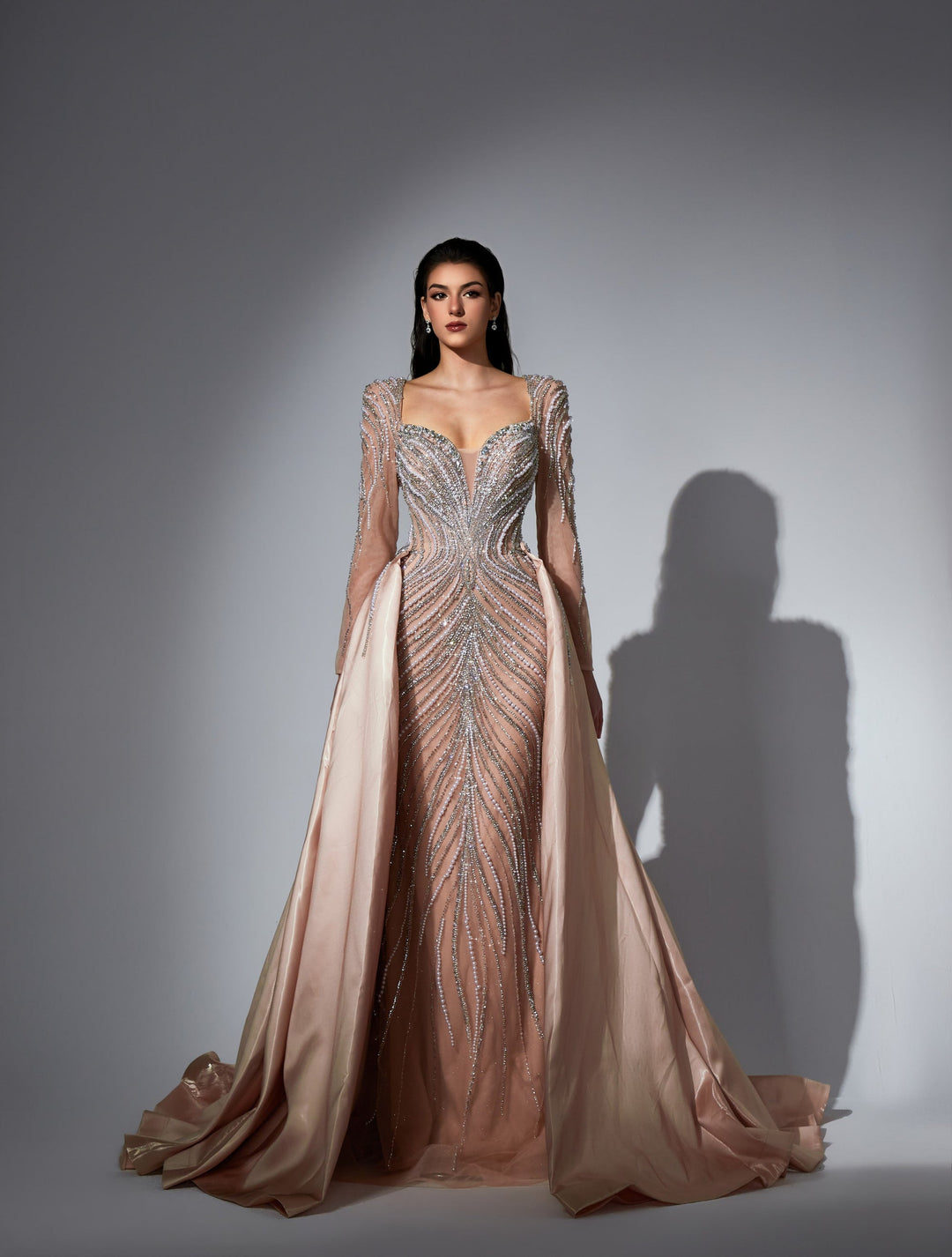Delilah LD11475 Plunging Illusion Long Sleeve Beaded Corset Sheath Gown with Overskirt - Champagne front view